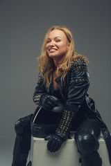 Naklejka premium Portrait of blond female in motorcycle uniforme with moto helmet