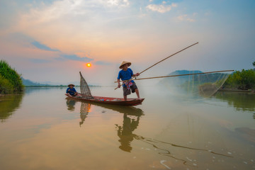 Fishermen in action when fishing in the mekong river , Thailand. - Powered by Adobe