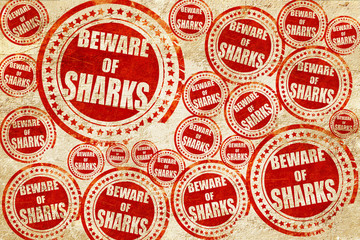 Beware of sharks sign, red stamp on a grunge paper texture