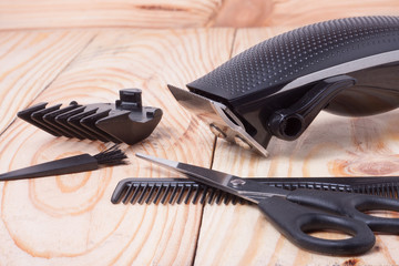 hair trimmer with comb and scissors on the wooden background