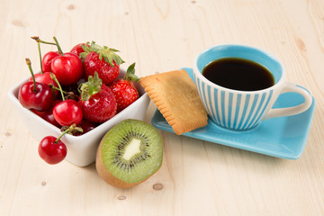 Coffee, cake and fruits on the wooden background