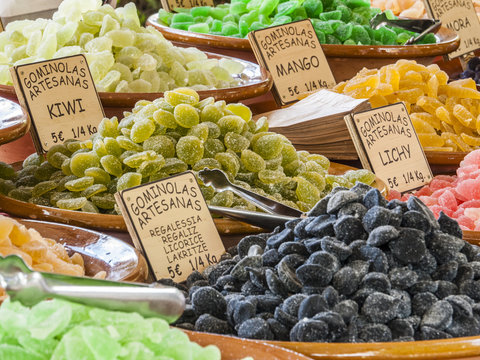 Traditional sweets (gominolas artesanas) made out of dried fruit (mango, kiwi, lichy) with sugar for sale on a market stand at Majorca, Spain, Europe - overview