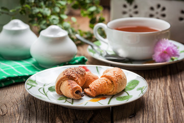 Breakfast with croissants, cup of tea.