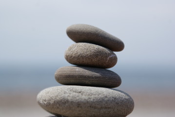 Balanced stones with sea and sky landscape background.