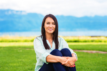 Portrait of young brunette woman resting outdoors