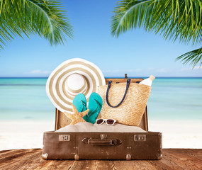 Old suitcase on tropical beach, travel concept