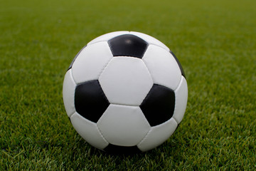 Fototapeta premium soccer ball on the green lawn near the gate of the gate