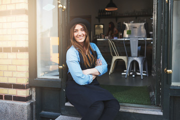 Smiling worker sitting in coffee house doorway