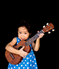 Obraz premium Little asian child play the ukulele