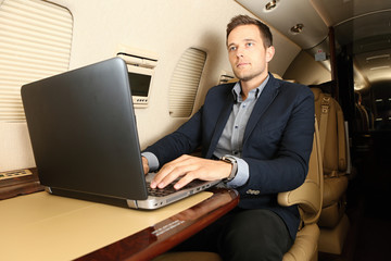 Man working on laptop in the aircraft cabin