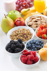 fresh berries, fruit and muesli for breakfast on white table