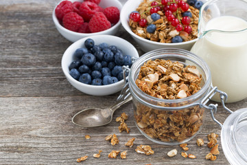 glass jar with granola, milk, and fresh berries 