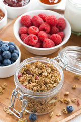 glass jar with homemade granola and berries, vertical, top view