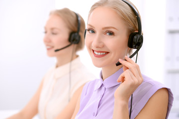 Call center. Focus on beautiful blonde woman in headset