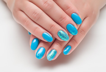 blue nail polish with glitter on the ring finger