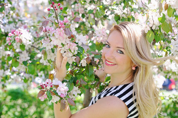 Fototapeta premium young woman in a flowering spring garden
