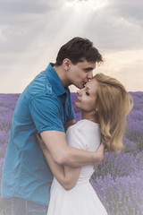 Happy young couple kissing each other on lavender field