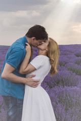 Happy young couple kissing each other on lavender field