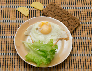 fried egg with toast and salad on a wooden table