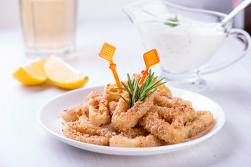 Fried squid rings with lemon, herbs and spices