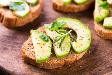 Toast with avocado, herbs on wooden board