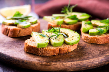 Toast with avocado, herbs on wooden board