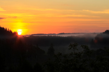 Sunrise and fog over wooded hills of Suwalki district