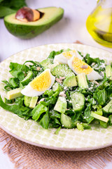Spinach and avocado salad on white plate