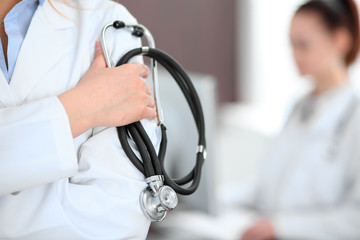 Female doctor standing in a hospital with her colleague in the background