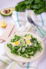 Spinach and avocado salad on white plate