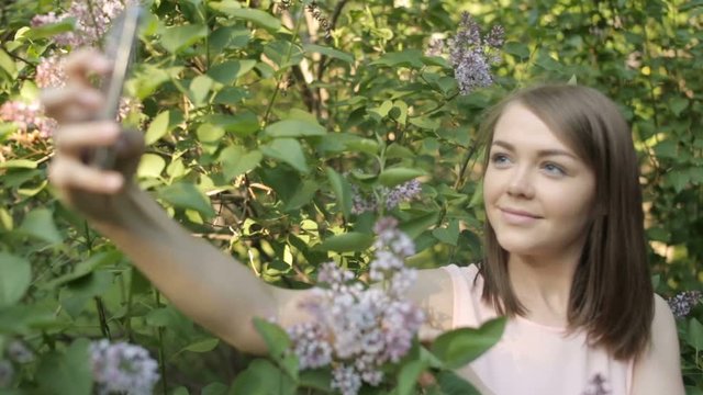 Beautiful girl is photographed in the lilac bushes