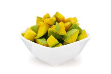 Organic sliced Indian Mango (Mangifera indica), seasoned with turmeric powder and salt in white bowl. Isolated on white background. Front view.