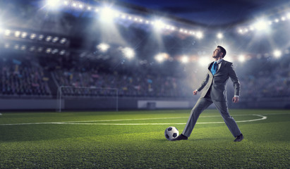 Businessman kicking ball