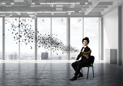 Businessman in cylinder reading book