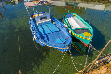 Fototapeta na wymiar Traditional fishing boats in Cyclades, Greece. Bright sunlight r