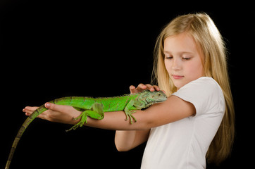 Happy little girl fnd green iguana in the studio  