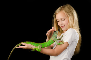 Obraz premium Happy little girl fnd green iguana in the studio 