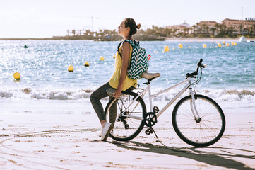 Fototapeta premium carefree woman with bicycle riding on beach sand having fun and