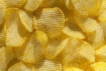 Backdrop of delicious potato chips with onion. Closeup