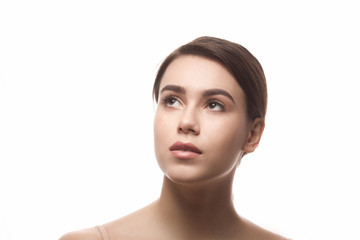 Closeup portrait of young woman's face looking away over white background. Beautiful lady showing her perfect skin of face.