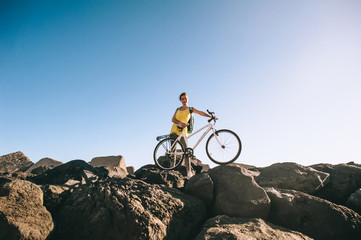 Fototapeta na wymiar sports girl cyclist stands on the stone beach