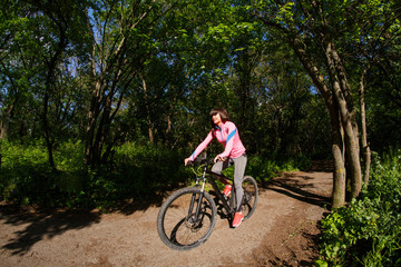 Young woman having fun riding a bicycle in the park.