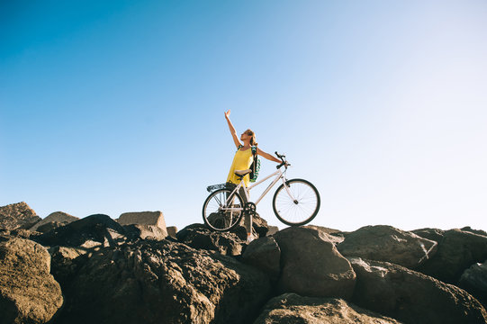 Sports Girl Cyclist Stands On The Stone Beach