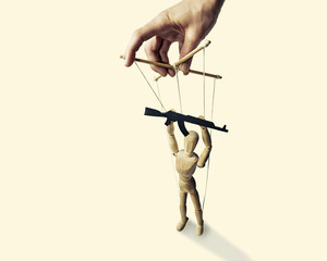 A puppet with  gun in the hands of the tyrant on the isolated toned background