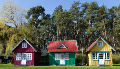 three multi-colored small house, tiny Homes on the lawn in the forest