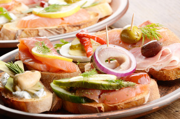 Open sandwiches with salmon, eggs, mussels, jamon and herring