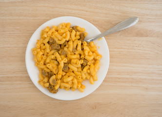 Mac and cheese with burger on plate with fork top view atop a wood table top