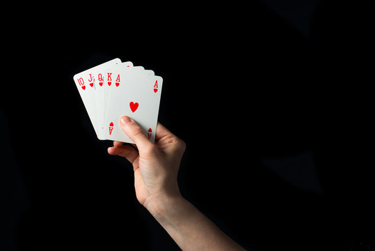Playing cards in hand isolated on black background