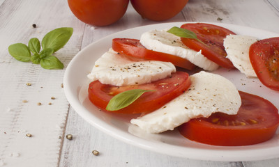 Caprese salad with mozzarella cheese, tomatoes and basil