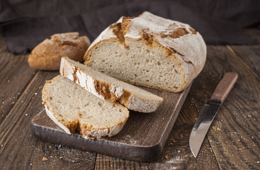 Sliced whole wheat bread and knife on rustic table, selective fo